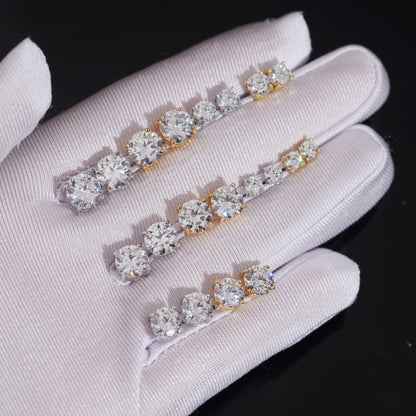 Moissanite stud earrings in white and yellow gold, multiple sizes on a jewelry display